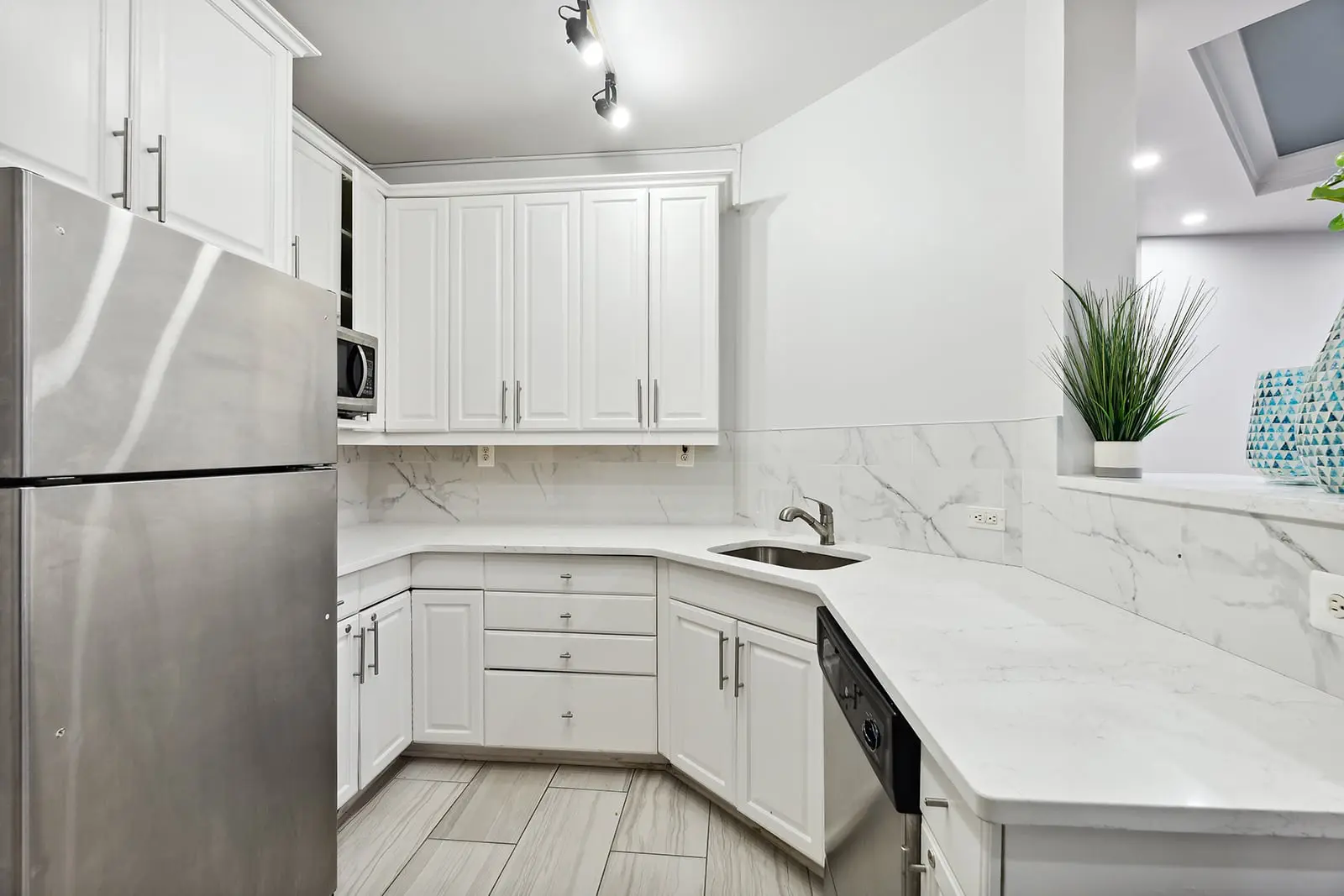 luxury fort lee apartment kitchen with stainless steel appliances and white cabinets